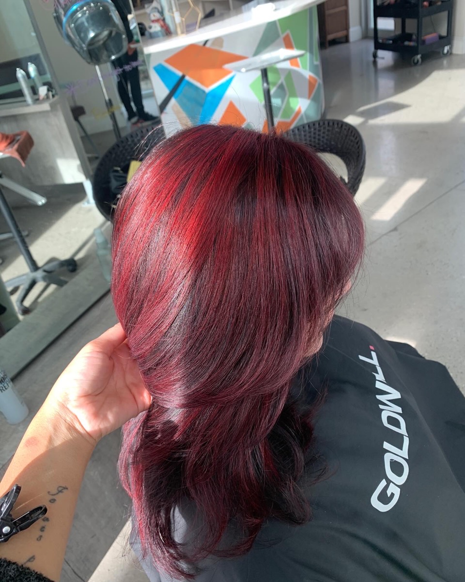 Vibrant red curled style by Hair by Isis